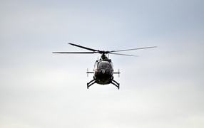 Большой черный вертолет летит в небе