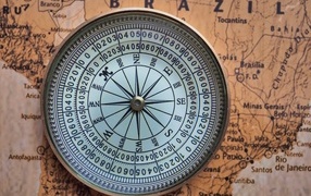 A large compass lies on an old map