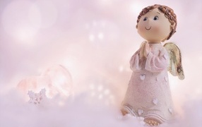 Статуэтка ангела на розовом фоне