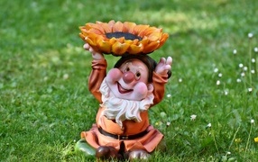 Садовая фигура гном за зеленой траве