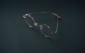 Очки лежат на серой поверхности