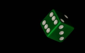 Green dice on black background