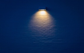 Lantern over a brick wall at night