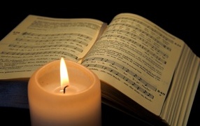 Lighted candle with music book