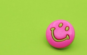 Pink emoticon on a green background