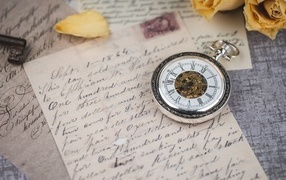Pocket watch with a letter on the table