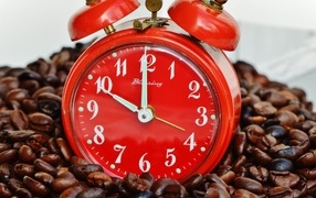 Red alarm clock with coffee beans