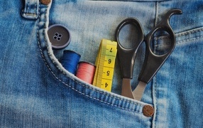 Scissors, thread and a centimeter in a jeans pocket