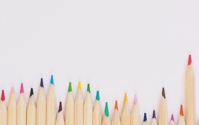 Острые разноцветные карандаши на сером фоне