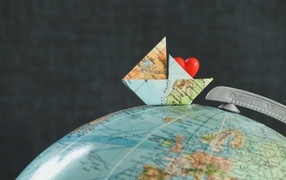 Кораблик из карты лежит на глобусе