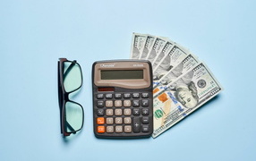 Calculator, glasses and dollars on a blue background