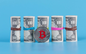 Доллары с монетой биткоин на голубом фоне