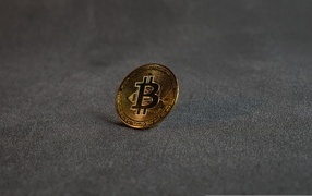 Gold coin bitcoin on a gray surface