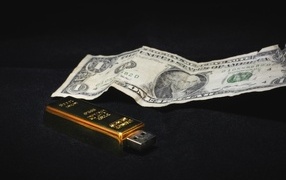 One dollar and a flash drive on a black background
