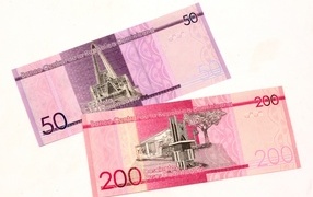 Two banknotes of the bank of the Dominican Republic on a white background