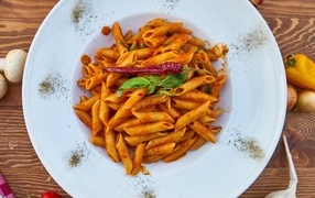 Boiled pasta on a large plate with red peppers