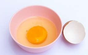 Разбитое яйцо на столе со скорлупой