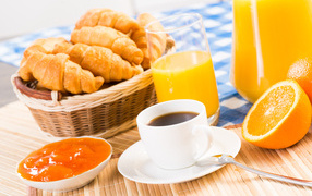 Coffee with croissants and juice on the table for breakfast