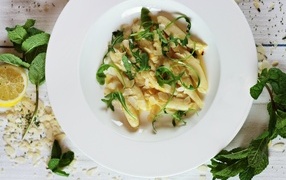 Блюдо с листьями рукколы в большой белой тарелке