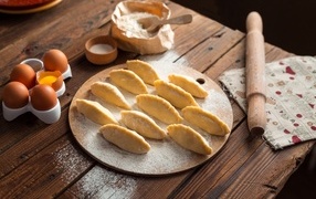 Вареники на столе  с яйцами и мукой