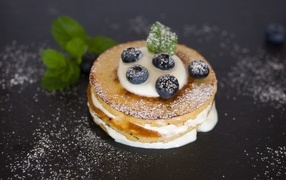 Оладьи с кремом и ягодами черники на столе