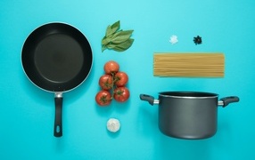 Ingredients and utensils for spaghetti on a blue background