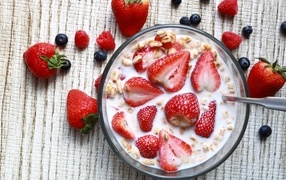 Oatmeal with milk in a plate with raspberries