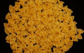 Pasta in the shape of bows on a black background