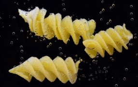 Макароны в воде на черном фоне