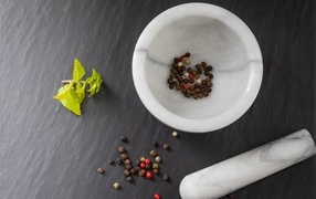 Peppercorns in a mortar on a gray table