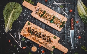 Роллы на деревянной доске на столе