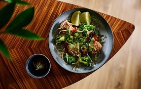 Салат на тарелке с кусочками лайма