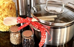 Кастрюля на столе с ложками, специями и лапшой