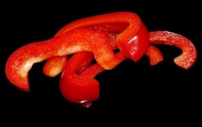 Нарезанный сладкий красный перец на черном фоне