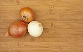 Three onions on a wooden table
