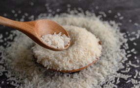 Белый рис на столе с деревянной ложкой 