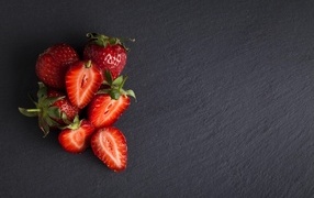 Горсть спелой клубники на сером столе