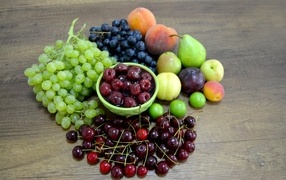 Аппетитные сладкие фрукты и ягоды на деревянном столе