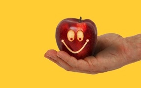 Яблоко на ладони на желтом фоне
