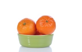 Красивые мандарины в миске на белом фоне