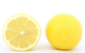 Большой желтый спелый лимон на белом фоне