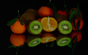 Цитрусовые фрукты на черной зеркальной поверхности