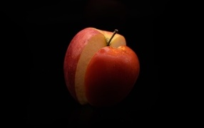 Разрезанное красное яблоко на черном фоне