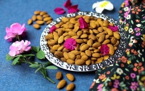 Delicious almonds on a plate with flowers
