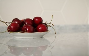 Delicious sweet cherries on a white plate
