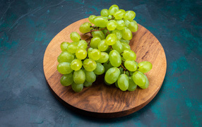 Зеленый виноград на деревянной доске