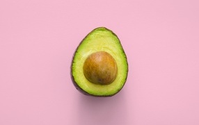 Half an avocado on a pink background
