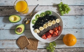 Полезный завтрак с ягодами и фруктами на столе с соком