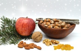 Орехи с яблоком и еловой веткой на столе