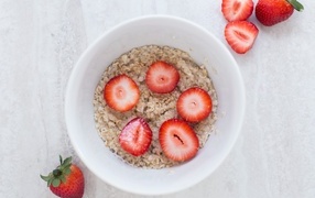 Овсяная каша с клубникой в белой тарелке 